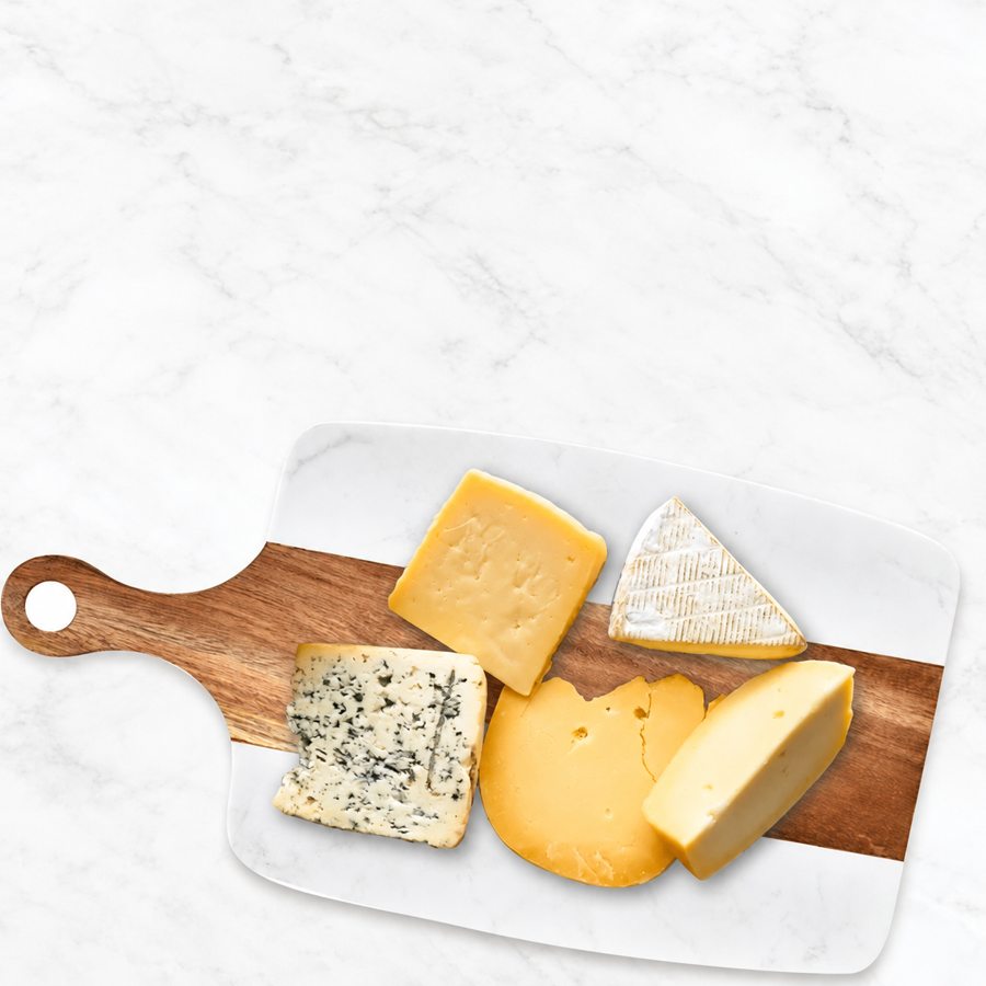Cheese served on a white and wood board

